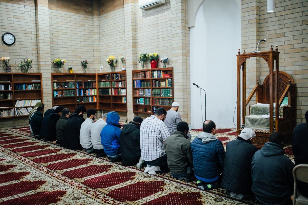 Worshippers in rows on the red carpet of the prayer hall at Idris Mosque